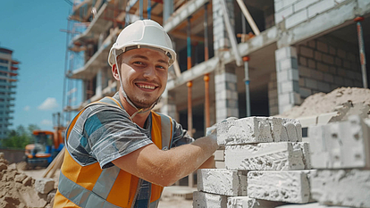 Maurer mit Schutzhelm arbeitet auf einer Baustelle an Mauersteinen. Ausbildung im Bauhandwerk bei der HIG Hoch- und Ingenieurbau GmbH in Gera